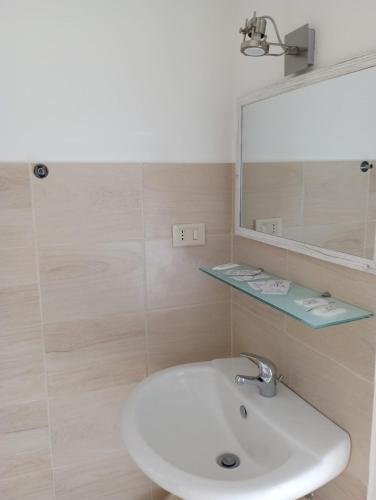 a bathroom with a white sink and a mirror at B&B La Maison in Canicattì