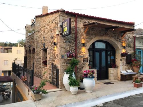 a stone building with three white vases in front of it at Idili in Panormos Rethymno