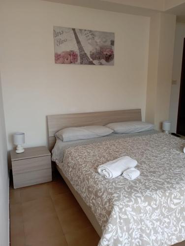 a bedroom with a bed with two towels on it at B&B La Maison in Canicattì
