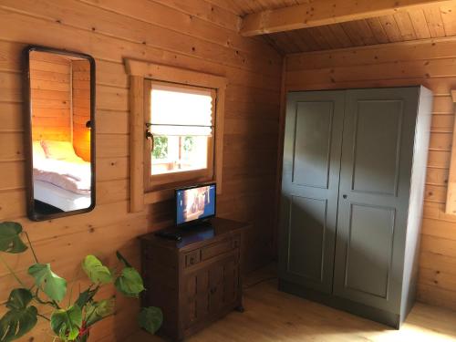 Zimmer mit einem Bett, einem Spiegel und einer Tür in der Unterkunft Domek drewniany in Podzamcze