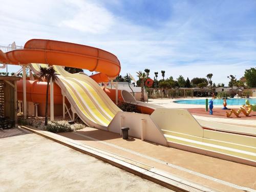 - un toboggan dans un parc aquatique avec une piscine dans l'établissement MOBIL HOME LE BIENVENUE 3 CH VALRAS PLAGE, à Valras-Plage