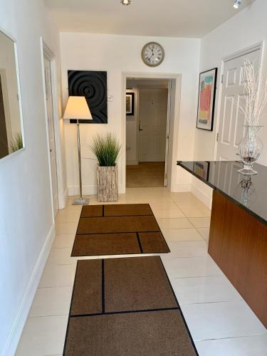 a living room with a table and a clock on the wall at Ferndale Mews in Bristol