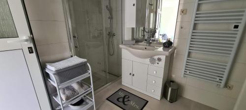 y baño blanco con lavabo y ducha. en Holiday home Green Point, en Grižane