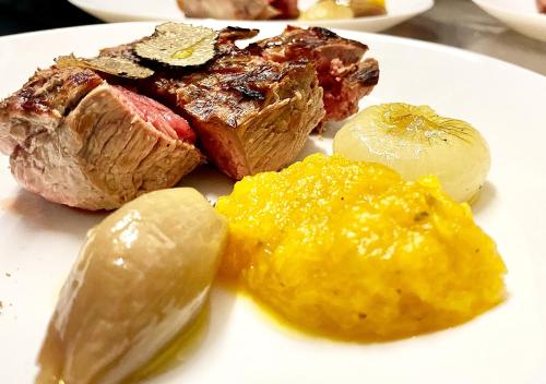 a plate of food with meat and vegetables on it at Camping Village la Verna in Chiusi della Verna