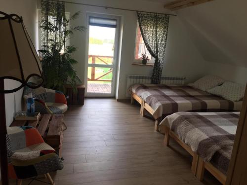 Zimmer mit 2 Betten und einem Fenster in der Unterkunft Zakątek Mikołajewo 14 in Mikolajewo