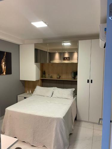 a bedroom with a large bed and white cabinets at Branco Haus - Pé na Areia do Caribessa in João Pessoa