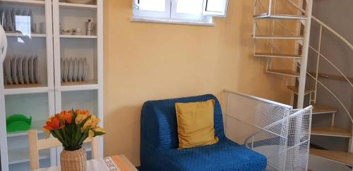 een blauwe stoel met een geel kussen in een kamer bij Casetta Miluna in Ischia