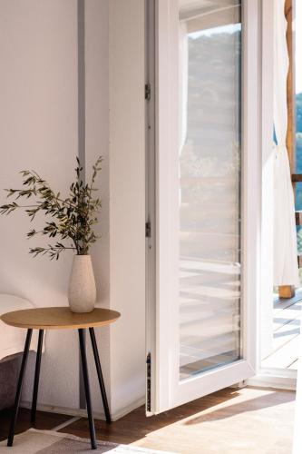 a vase on a table next to a sliding glass door at Nature House with a wooden porch - Pasika, house Tonka in Pučišća