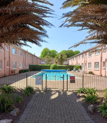 a fence with a pool in front of a building at 50 New Esplanade Court in Paignton