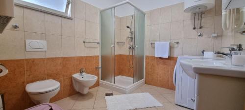 a bathroom with a shower and a toilet and a sink at Apartments Anamarija in Opatija