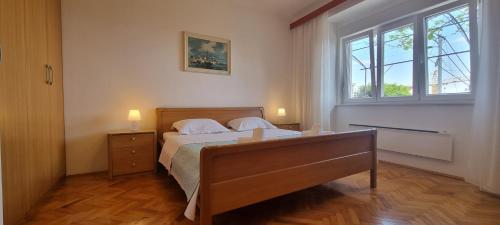 a bedroom with a bed and a dresser and a window at Apartments Anamarija in Opatija