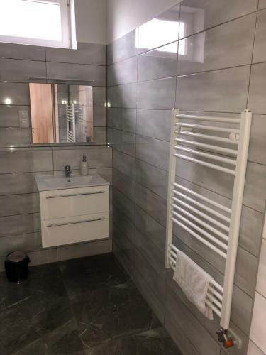 bagno con lavandino e specchio di Pupos Apartman Szigliget a Szigliget