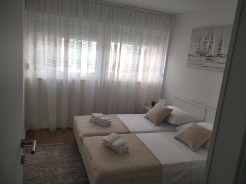 una camera da letto con due letti con asciugamani sopra di Apartment Mateo a Spalato (Split)