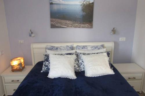 een slaapkamer met een bed met blauwe lakens en kussens bij Mory's Place - Luxurious Holiday Apartment in Arad