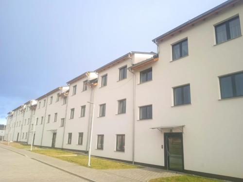 a row of white buildings on a street at Przytulny apartament w sercu Karkonoszy in Jelenia Góra