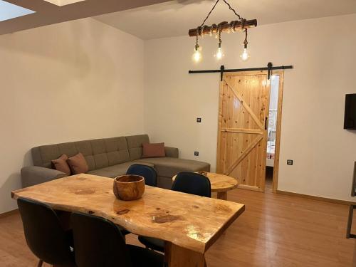 - un salon avec une table en bois et un canapé dans l'établissement Olivelia, à Ixia