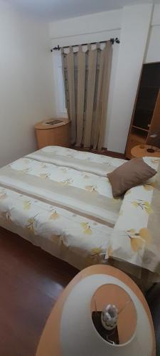 Un dormitorio con una cama y una mesa con un gato. en Emperador Carlos, en San Fernando
