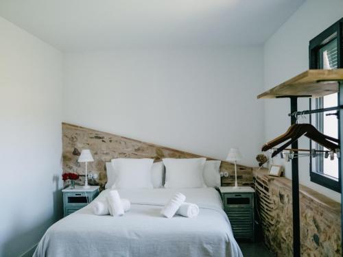 a bedroom with a white bed with towels on it at Can Serrà 1786 in Llagostera