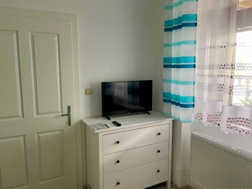 a bedroom with a dresser with a tv on top of it at Penzion u Vlčků in Cheb