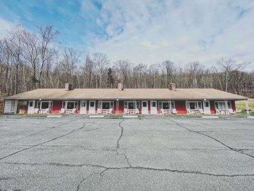 a red and white building with an empty parking lot at Berkshire Valley Inn in North Hancock