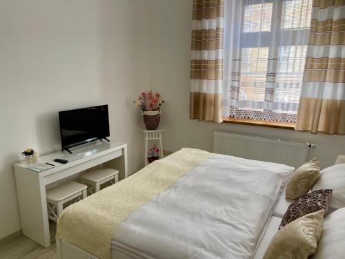 a small bedroom with a bed and a television at Penzion u Vlčků in Cheb