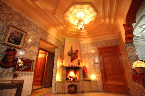a living room with a fireplace and a ceiling at Auberge Lion de l'Atlas in Azrou