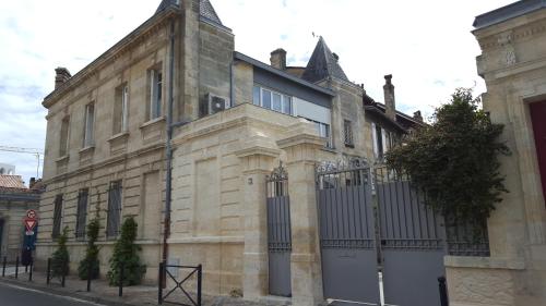 an old stone building with a gate on a street at La Halte Montaigne in Bordeaux