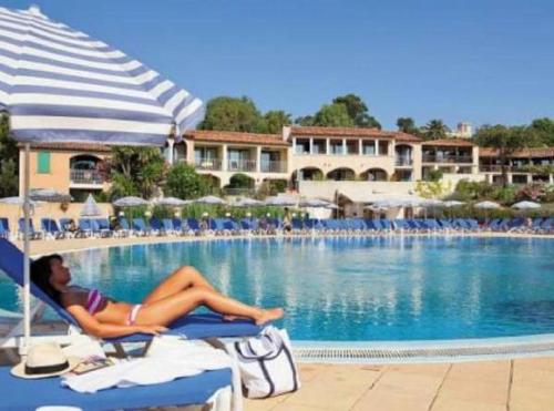 eine Frau, die auf einem Strandkorb neben einem Pool liegt in der Unterkunft Chez Adriana Studio Proche Mer avec Piscine in Grimaud