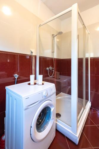 a washing machine in a bathroom with a shower at Vecchia Donna in Kaštela
