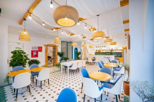 Santori Hotel And Spa في دا نانغ: مطعم به كراسي وطاولات زرقاء وبيضاء