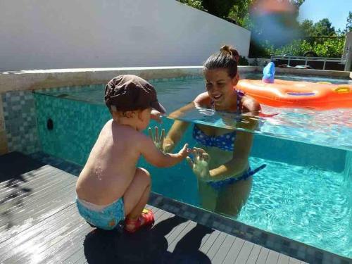 two children playing in a swimming pool at Très belle maison avec piscine , proche centre ville - Aix en Provence in Aix-en-Provence