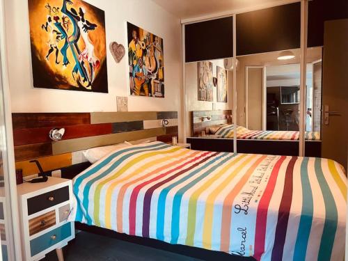 - une chambre avec un lit rayé et un miroir dans l'établissement Très belle maison avec piscine , proche centre ville - Aix en Provence, à Aix-en-Provence