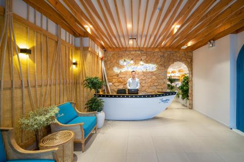 a man standing in a lobby with a tub at Santori Hotel And Spa in Da Nang