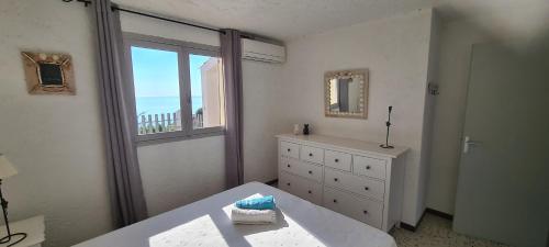 a bedroom with a bed and a window and a dresser at Belvedere de Canaloro in Sari Solenzara