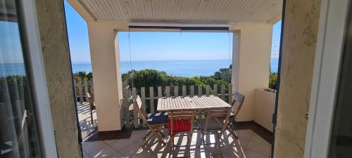 a patio with a table and chairs on a balcony at Belvedere de Canaloro in Sari Solenzara
