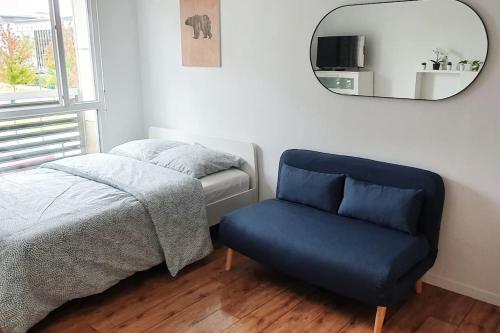 a bedroom with a bed and a chair and a mirror at Little Explorer*Studio*DisneyLand*ValDeurope*Paris in Montévrain