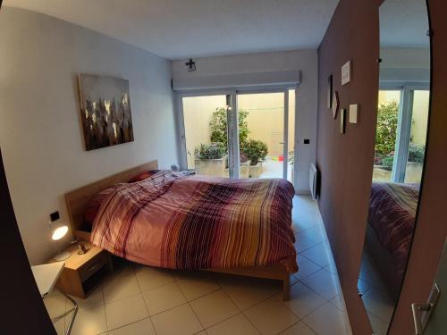 - une chambre avec un lit et une porte donnant sur un balcon dans l'établissement Superbe appartement de 94m2 avec vue sur le Fort St Elme, à Collioure