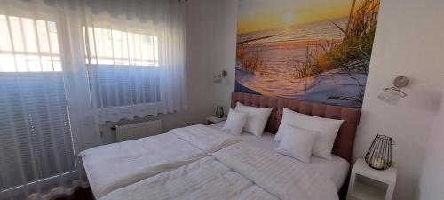 a bedroom with a bed with white sheets and pillows at Apartament Riva in Pobierowo