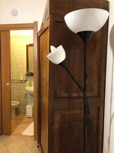 une lampe au sol dans une salle de bains à côté d'une porte dans l'établissement Locazione Turistica sita in via Ponte di Ferro 2 a Gualdo Cattaneo, à Gualdo Cattaneo