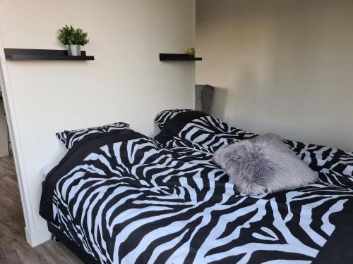 a bed with a zebra blanket on it at Tiny house in de Achterhoek in Voorst