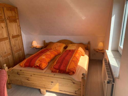 a bedroom with a wooden bed with two pillows at Appartement Möhlkiek in Nordstrand