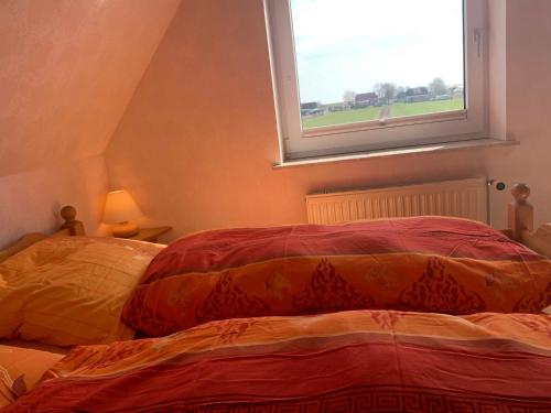 a bedroom with two beds and a window at Appartement Möhlkiek in Nordstrand