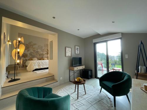 um quarto com uma cama, 2 cadeiras e uma mesa em Villa la Dunette & spa em Vaux-sur-Mer