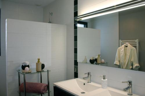 a bathroom with a sink and a mirror at Villa la Dunette & spa in Vaux-sur-Mer