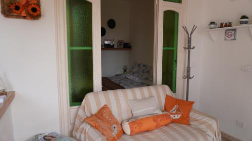 ein Wohnzimmer mit einem Sofa und einem Spiegel in der Unterkunft Appartamento Arte e Mare in Bordighera