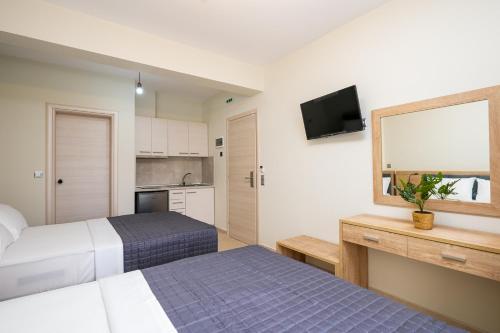 ein Hotelzimmer mit 2 Betten und einem TV in der Unterkunft Villa MARIA in Nea Vrasna