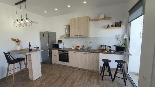 a kitchen with a counter and some stools in it at Elizabeth Suites in Kato Daratso