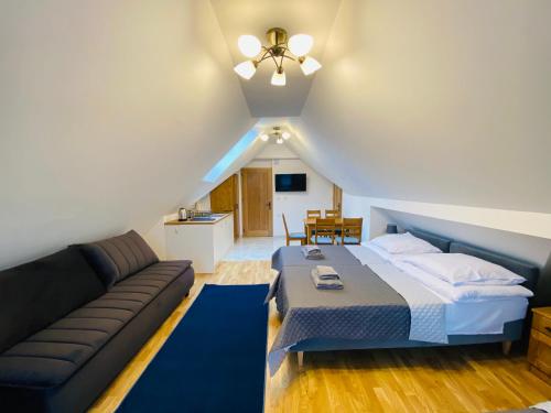 a bedroom with a bed and a couch at Willa FOLK Pieniny in Szczawnica