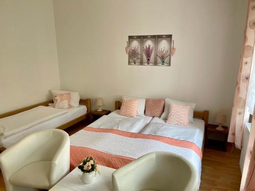a room with two beds and a chair in it at Penzion u Vlčků in Cheb