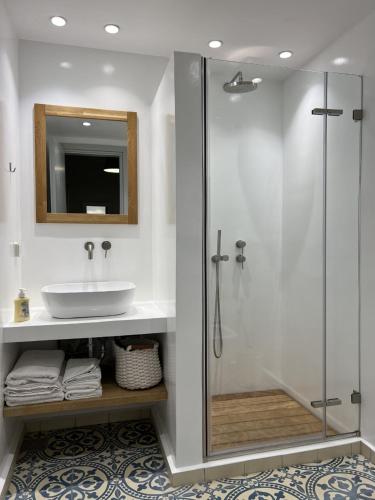a bathroom with a sink and a glass shower at Mercato Vecchio House in Hydra